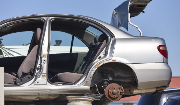 Car scrapyard. Stacked damaged vehicles ready to be recycling. Automotive